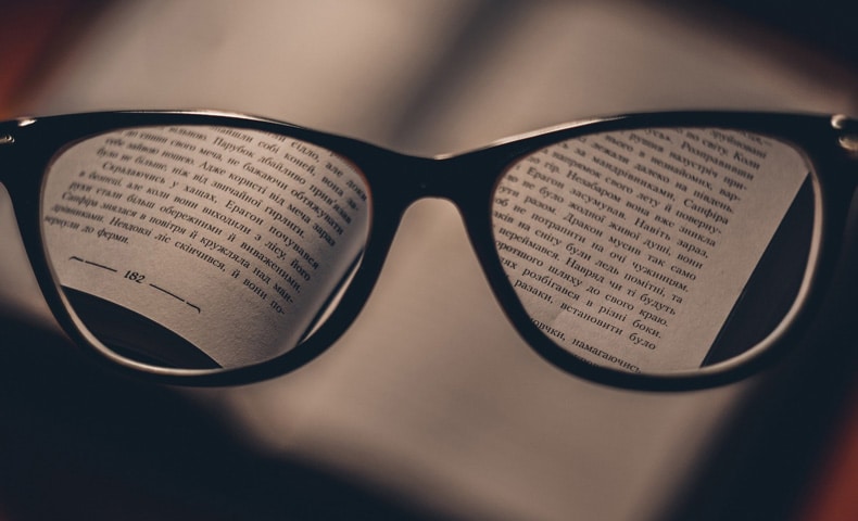 View Of A Blurry Book With Reading Glasses