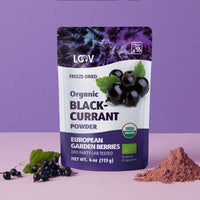 “A stand-up pouch of LOOV Freeze-Dried Organic Blackcurrant Powder in white and purple packaging. The front shows ripe blackcurrant imagery along with a green organic certification seal. Next to the pouch is a small heap of deep purple powder.”